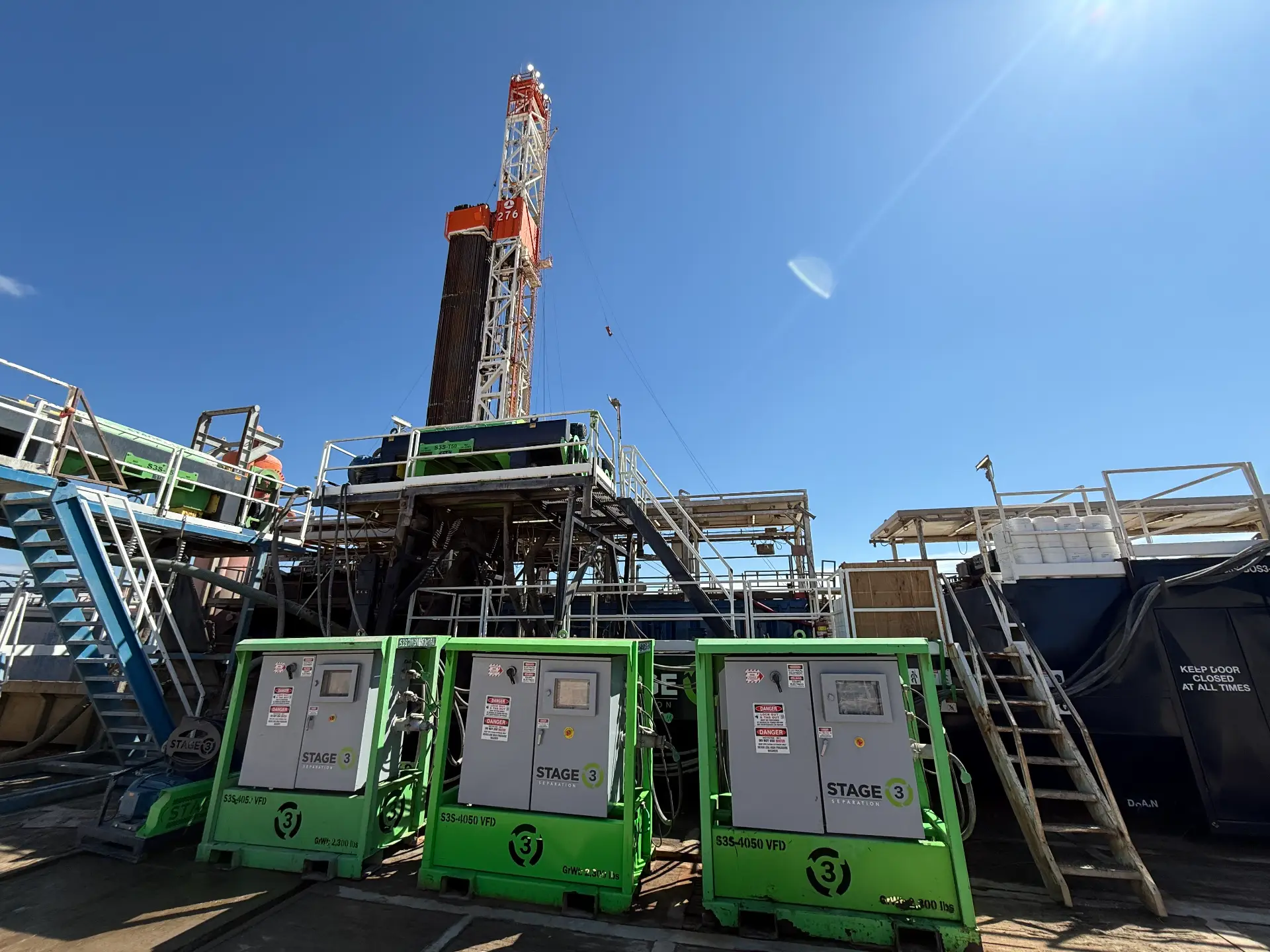 WOS-supported drilling rig with Stage 3 separation units in the foreground on a clear Bakken day