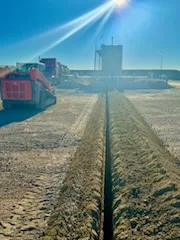 Trenched flare line on a Bakken rig pad at sunrise