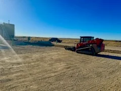 WOS tracked skidsteer working a Bakken pad at sunset