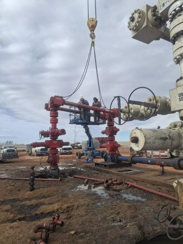 WOS crew on a manlift platform working a wellhead
